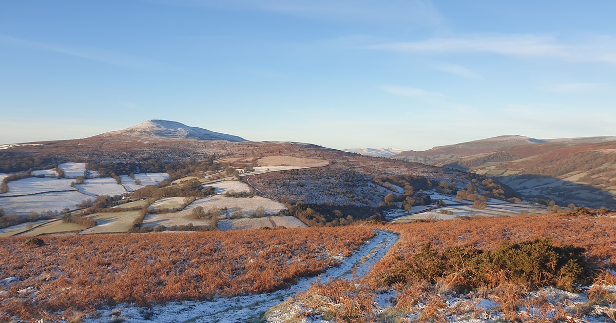 Standing on Bryn Arw looking at the Snow on the Sugar Loaf with Pen Y Fan in the far Distance